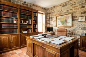 Bureau d'avocat traditionnel dans les Pyrénées-Orientales avec bibliothèque juridique, documents et architecture catalane