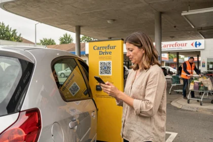 Femme utilisant un code promo Carrefour Drive sur son smartphone au retrait de sa commande